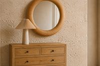Mediterranean bedroom dresser with natural wood, sculptural table lamp and round mirror in a calm and relaxed Mallorca interior. Mediterranean bedroom dresser with natural wood, sculptural table lamp and round mirror in a calm and relaxed Mallorca interior.