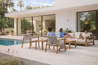 Mediterranean outdoor lounge area with teak sofa, armchair and table on villa terrace