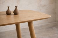 close up of custom oak dining table with rounded edge and natural finish in mediterranean interior mallorca