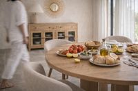 mediterranean dining table in mallorca with natural wood, olive oil, bread and fresh food in a warm lifestyle setting