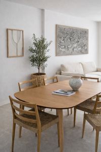Wooden dining table in Mallorca-style living space with natural light, neutral tones and Mediterranean decor