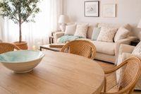 Relaxed Mediterranean living room at Palma Tennis Club with warm wood furniture, natural textures, rattan dining chairs and soft