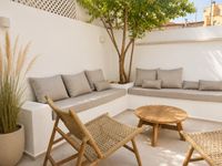 Private Mediterranean courtyard with outdoor dining area and lounge seating in a renovated Santa Catalina townhouse, Mallorca.