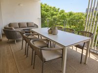Terraza contemporánea en Es Molinar con comedor exterior, alfombra outdoor y lounge relajado con vistas verdes en Palma de Mallorca.