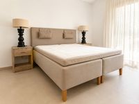 Swedish Princess box spring bed in a calm Mallorca countryside home with handcrafted wooden bedside tables, soft neutral fabrics and relaxed Scandinavian-inspired bedroom styling.