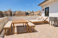 Sunny rooftop terrace in Santa Catalina with teak dining furniture, sun loungers and views over Palma.