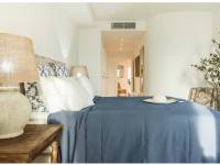 Hamptons-style bedroom in Portixol with blue textiles, rustic wood details and relaxed Mediterranean atmosphere near the sea in Palma de Mallorca.