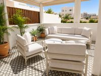 Outdoor lounge terrace at Palma Tennis Club with soft neutral outdoor furniture, Mediterranean plants and patterned tiled flooring in a relaxed urban Mallorca setting.